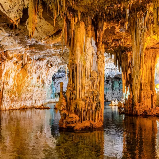 Die Saalfelder Seengrotte in Thüringen mit faszinierenden Tropfsteinformationen, die sich in einem glasklaren unterirdischen Salzsee spiegeln.