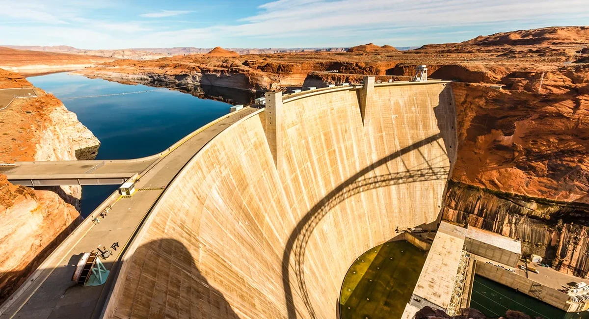 Vogelperspektive auf den Hoover Dam in den USA mit Staumauer und Flusslauf.
