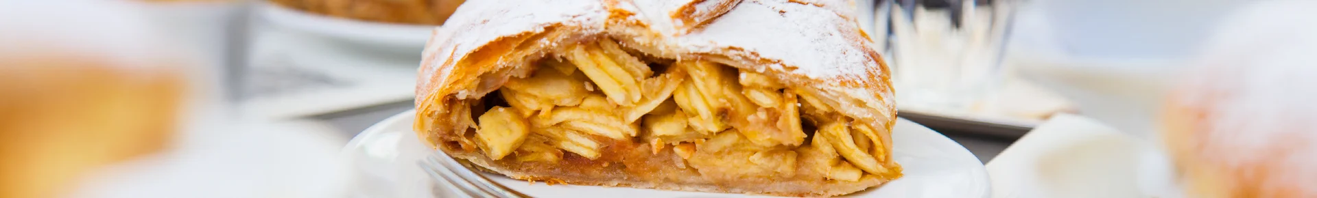 Ein traditioneller österreichischer Apfelstrudel mit Puderzucker auf einem Teller in Wien.